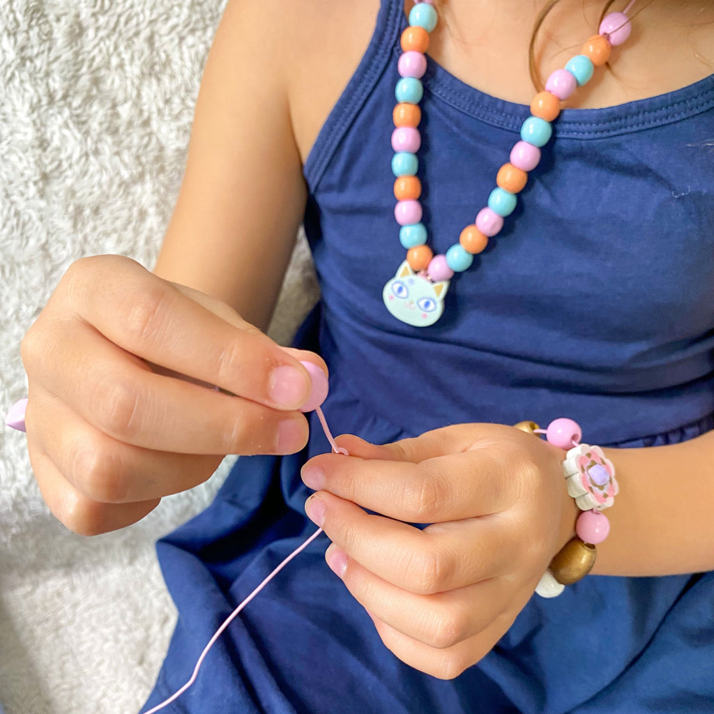 Girl threading necklace with beads