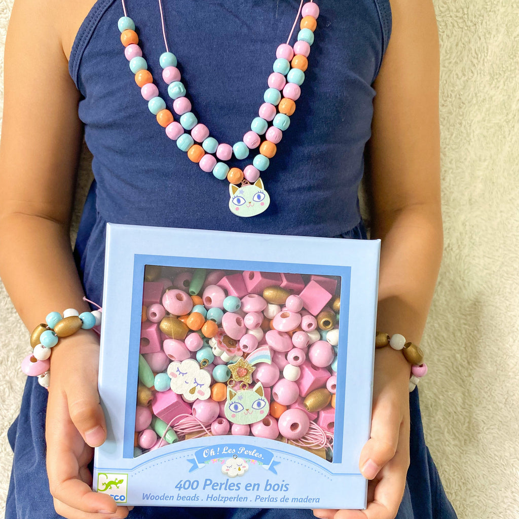 Girl holdinf box of beads and wearing beaded necklace and bracelete