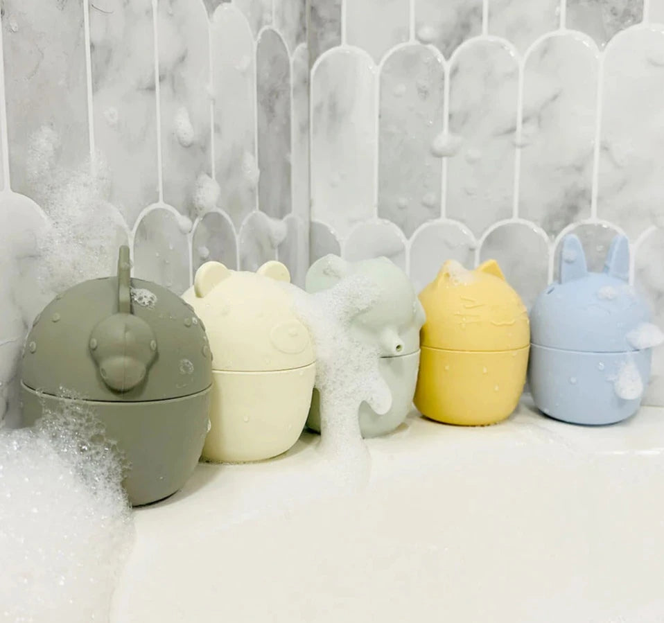 Child playing with Cherub Baby  Silicone Squeeze and Squirt 5 Pk lined up with marble finger  tiles in bathroom