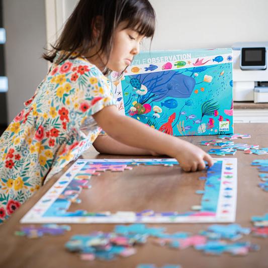 Girl playing with aquatic observation puzzle
