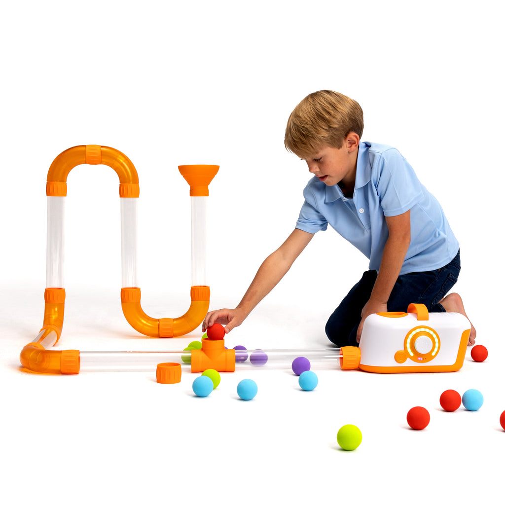 Child playing on floor with Fat Brain Toys Air Toobz 