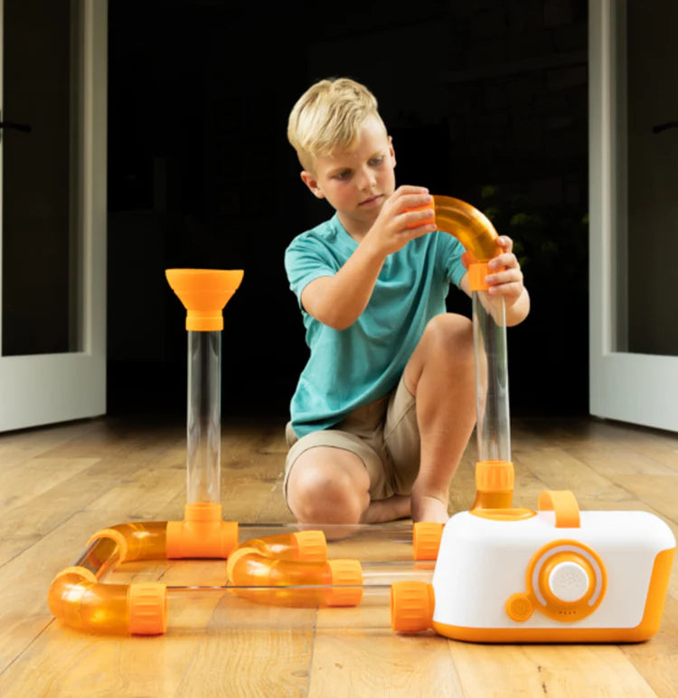 Child playing on floor with Fat Brain Toys Air Toobz Air-Powered STEM Building Toy