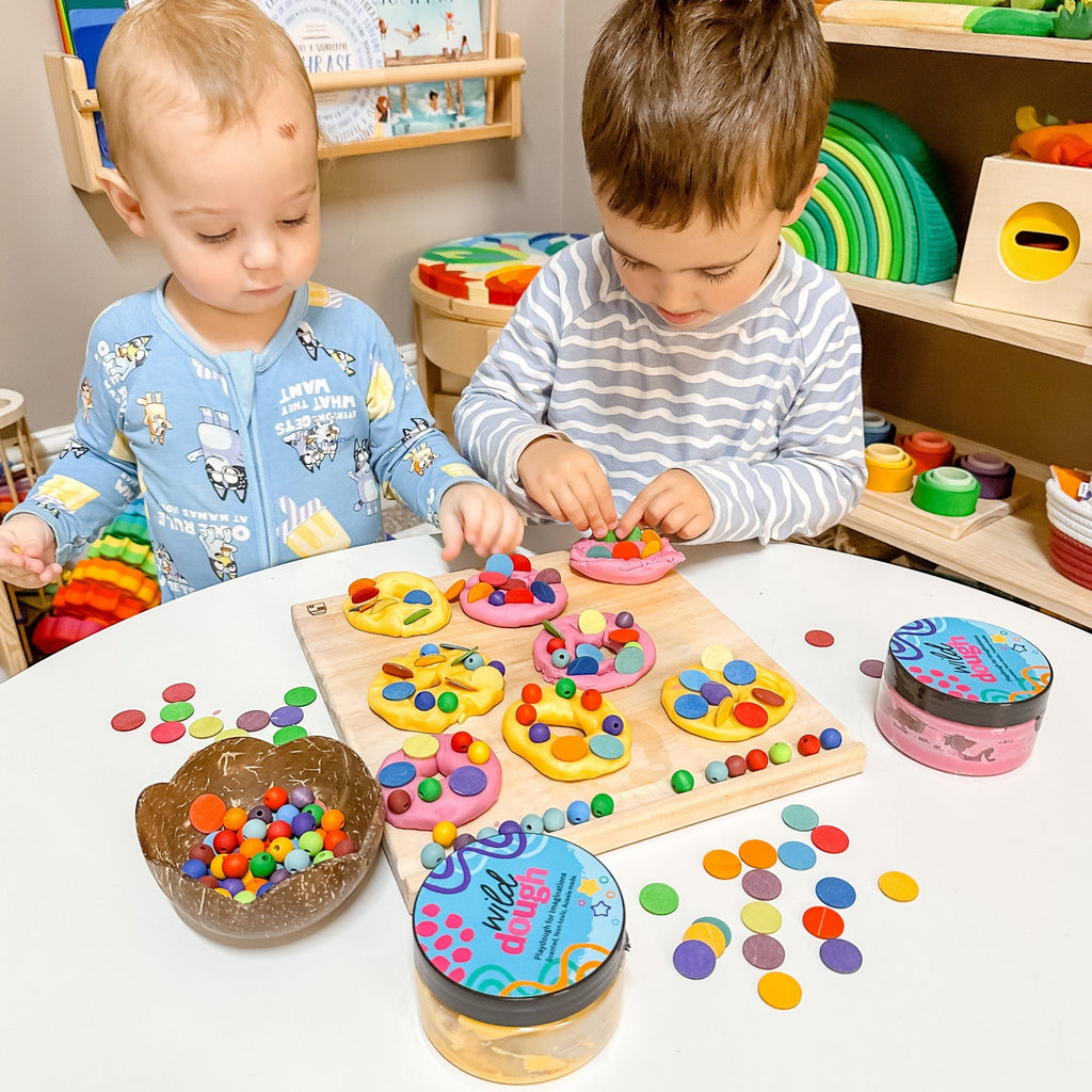 Children playing with Playdough donuts made from Wild Dough and colourful beads and loose parts