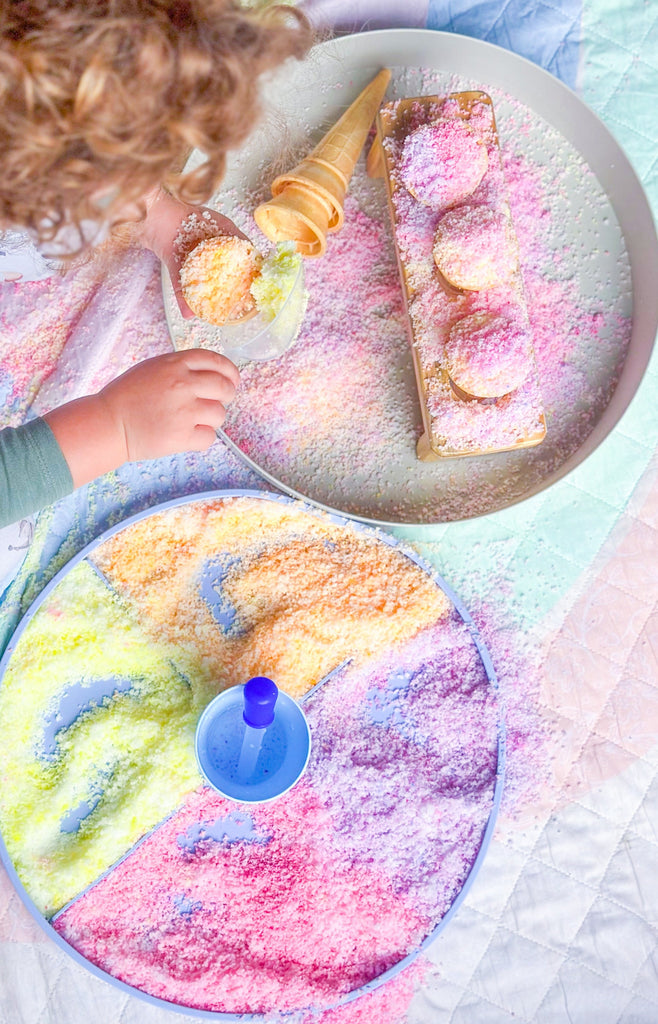 Child playing with natures flurry making icecream cones in the jellystone play tray set up  on a colourful play quilt