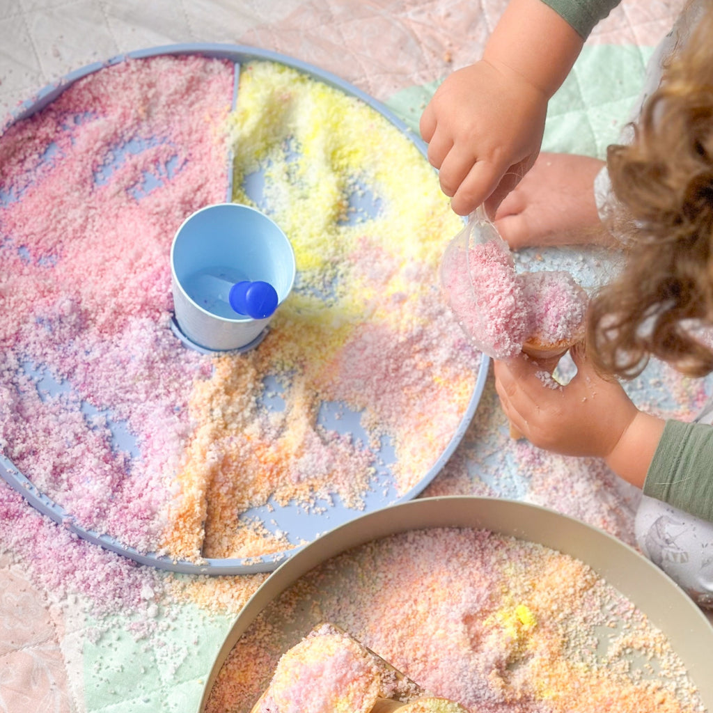 Child playing with natures flurry making icecream cones in the jellystone play tray set up  on a colourful play quilt