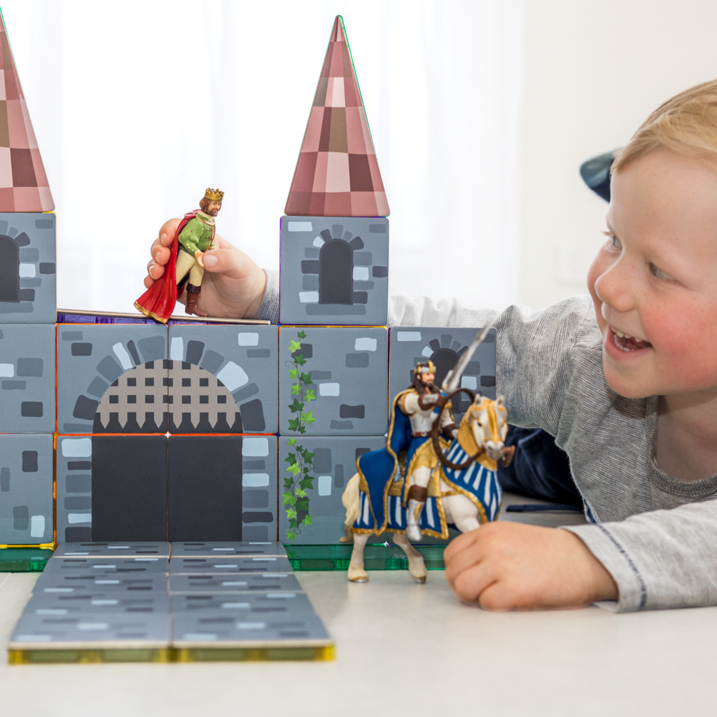 Child playing with Castle tile toppers and plastic king and knights 