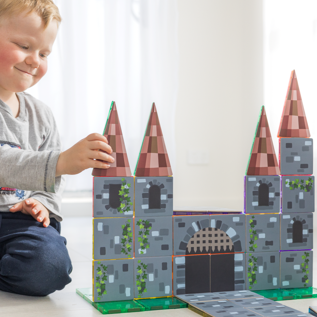 Child playing with Castle tile toppers on the floor