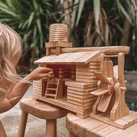 Explore-Nook-Eco-Hut-Water-Wheel played with by a child with curly blonde hair