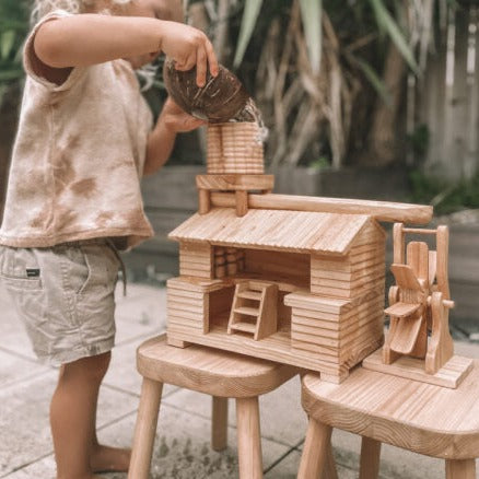 Explore-Nook-Eco-Hut-Water-Wheel played with a child with curly blonde hair